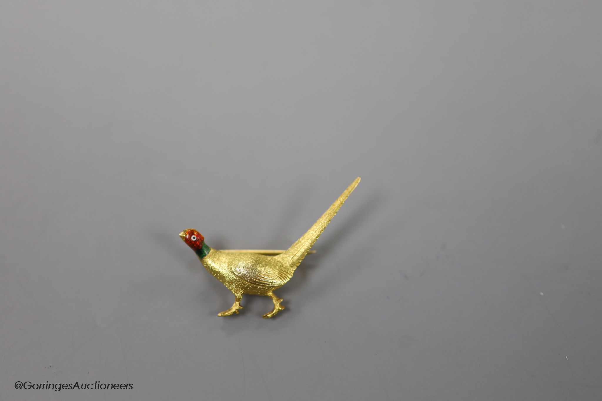 An early 20th century 9ct and polychrome enamel pheasant brooch, 42mm, gross weight 6.4 grams.